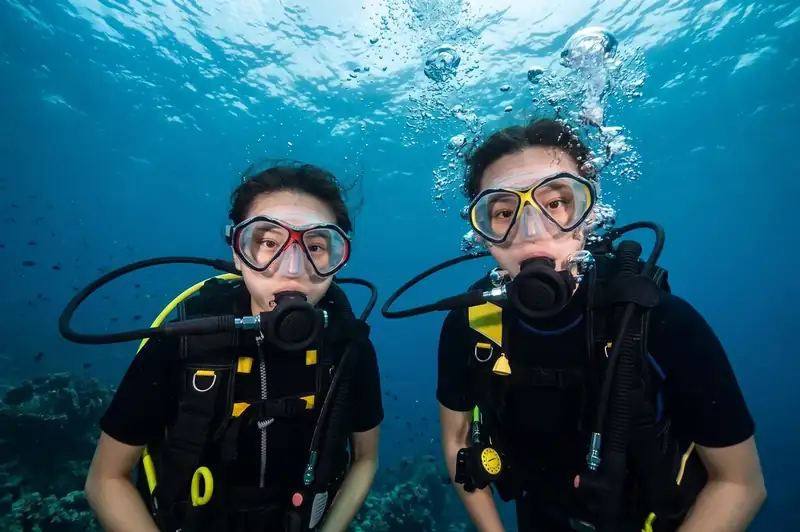 Expert dive buddy guiding scuba divers with Turtle Seaweed Resort in the Semporna